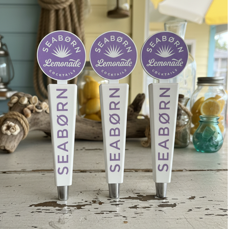 Four Seaborn Lemonade tap handles on a rustic wooden surface with a nautical theme.
